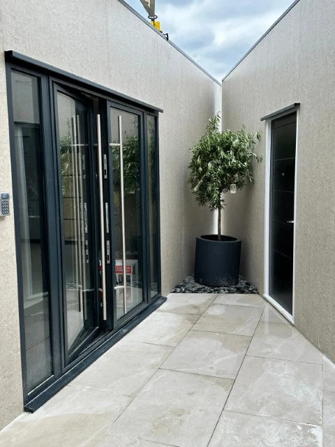 Modern modular building exterior with glass doors and paved walkway